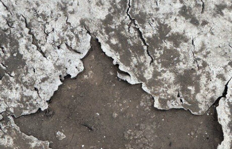 Cracked and deteriorating commercial roof coating exposing underlying substrate in Phoenix Arizona