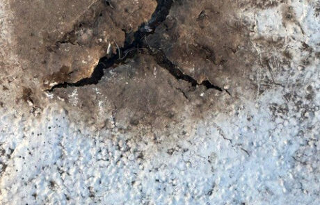 Severely deteriorated roof area with deep cracking and exposed material on commercial building