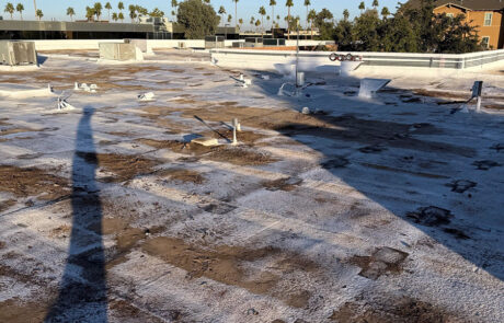 Commercial roof showing widespread discoloration, UV degradation, and coating failure