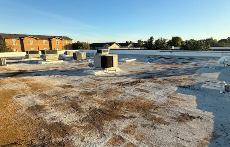 Flat commercial roof in Phoenix with visible dirt accumulation, coating wear, and early-stage surface degradation identified during inspection