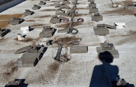 Flat commercial roof inspection in Phoenix showing coating wear, debris, and rooftop system layout with technician shadow visible during evaluation