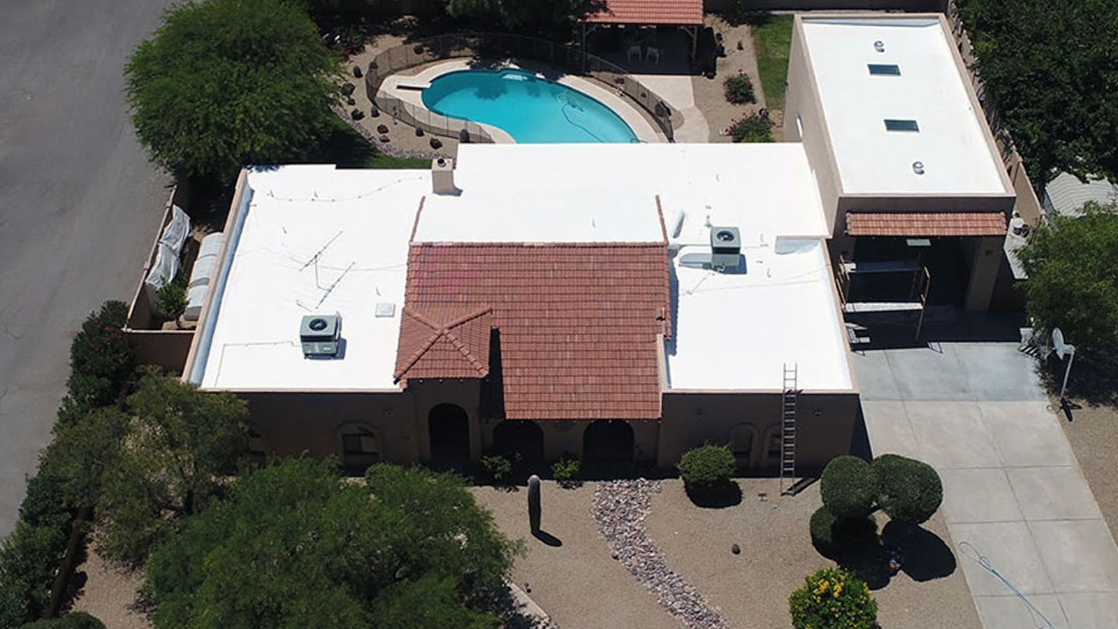 Aerial view of an Arizona home with a white foam roof coating, showing typical SPF roofing used in the Chandler and Scottsdale region.